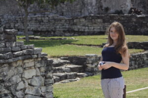 Girl stands among Tulum Mayan Ruins