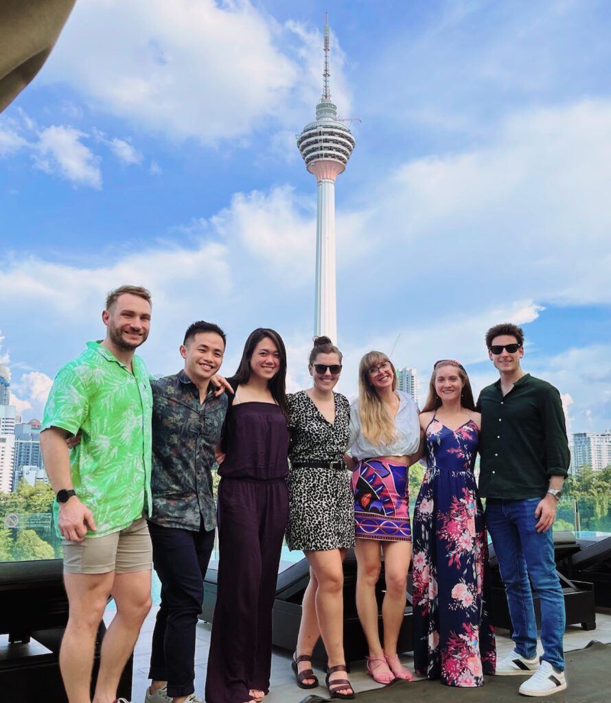 Seven people stand in front of Kuala Lumpur tower